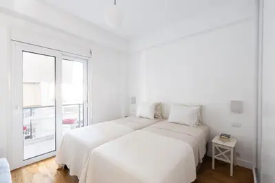 a white bedroom with a large bed and a window at Wonderful Central Athens 2 Bedroom 2 Bath Sleeps 8 in Athens