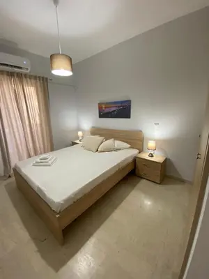 a bedroom with a large bed and two night stands at Christy's House Anavissos / Ανάβυσσος in Anavissos