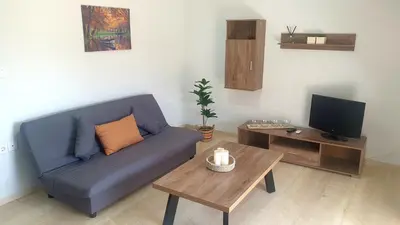 a living room with a blue couch and a coffee table at Christy's House Anavissos / Ανάβυσσος in Anavissos