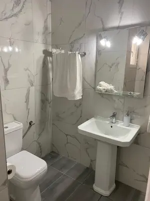 a white bathroom with a sink and a toilet at Christy's House Anavissos / Ανάβυσσος in Anavissos
