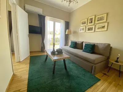 a living room with a couch and a green rug at Check Point - Acropolis View A in Athens