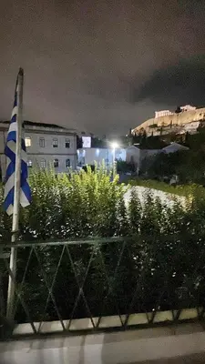 a view of a city at night with a flag at Check Point - Acropolis View A in Athens