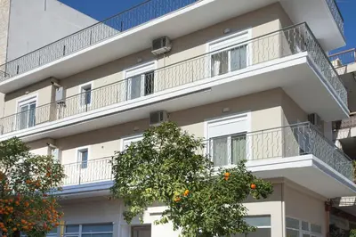 an apartment building with balconies and an orange tree at Διαμερίσματα στο Δυτικό Μοσχάτο in Piraeus