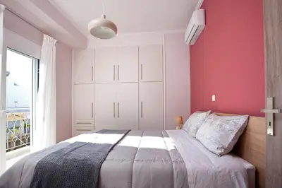 a bedroom with pink walls and a large bed at Διαμερίσματα στο Δυτικό Μοσχάτο in Piraeus
