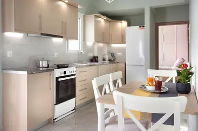 a kitchen with a table and a white refrigerator at Διαμερίσματα στο Δυτικό Μοσχάτο in Piraeus