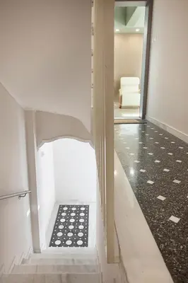 a hallway with a staircase with a room with a chair at Διαμερίσματα στο Δυτικό Μοσχάτο in Piraeus