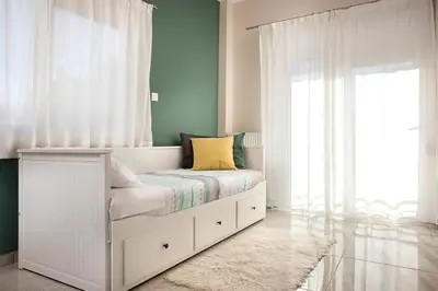 a bedroom with a white bed with a window at Διαμερίσματα στο Δυτικό Μοσχάτο in Piraeus