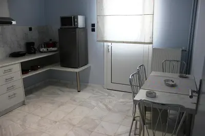 a kitchen with a refrigerator and a table with chairs at Modern house next to Metro station to explore Athens in Athens