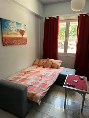 a bedroom with a bed and a table and a window at Modern house next to Metro station to explore Athens in Athens
