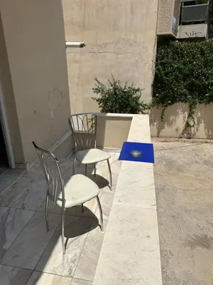 two chairs and a blue table on a patio at Modern house next to Metro station to explore Athens in Athens