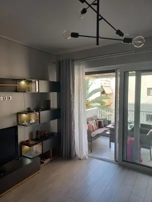 a living room with a sliding glass door and a living room at Lovely Faliro Apartment next to the sea. in Athens