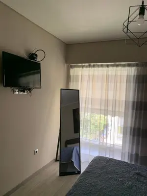 a bedroom with a mirror and a television on the wall at Lovely Faliro Apartment next to the sea. in Athens