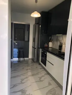 a kitchen with black and white appliances and a table at Lovely Faliro Apartment next to the sea. in Athens
