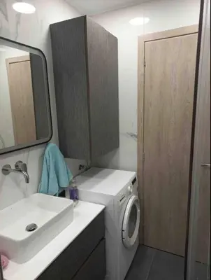 a bathroom with a washing machine and a sink at Lovely Faliro Apartment next to the sea. in Athens