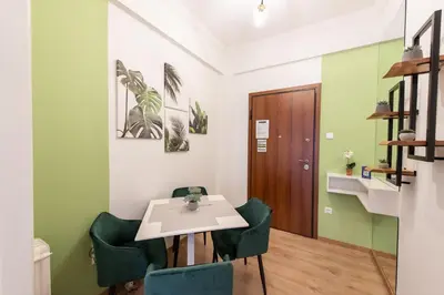 a dining room with a table and green chairs at MEDLUXE COMFORT APARTMENT in Athens