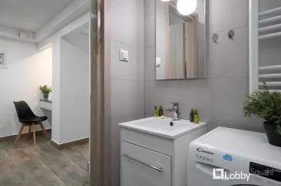 a white bathroom with a sink and a mirror at Embassy Studio in Athens