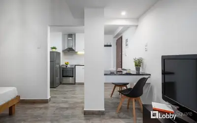 a living room with a table and a kitchen at Embassy Studio in Athens