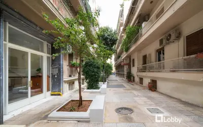 an empty alley with a tree in the middle of a building at Embassy Studio in Athens