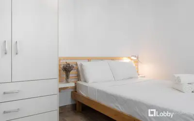 a bedroom with a bed and a white cabinet at Embassy Studio in Athens
