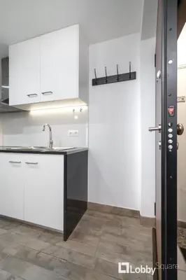 a kitchen with white cabinets and a sink at Embassy Studio in Athens