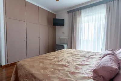 a bedroom with a bed and a large window at Ioanna's Hellenic Hospitality in Athens