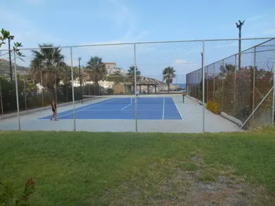 two people playing tennis on a tennis court at Katerina summerhouse in Dhaskalión