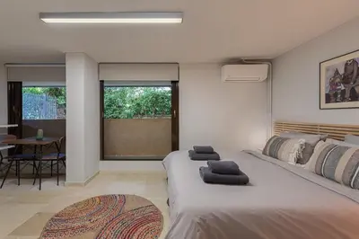 a bedroom with a large bed and a table at Studio Krinon - Paleo Psychiko in Athens