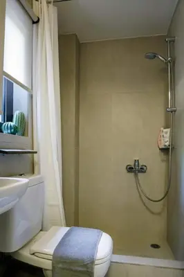 a bathroom with a shower and a toilet and a sink at Studio Krinon - Paleo Psychiko in Athens