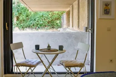 a table and two chairs in front of a window at Studio Krinon - Paleo Psychiko in Athens