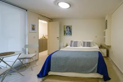 a bedroom with a large bed and a table and chair at Studio Krinon - Paleo Psychiko in Athens
