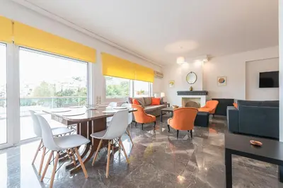 a living room with a table and chairs and a couch at Luxury Penthouse in Kolonaki with view in Athens