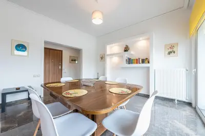 a dining room with a wooden table and white chairs at Luxury Penthouse in Kolonaki with view in Athens