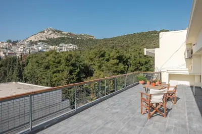a balcony with a table and chairs on a building at Luxury Penthouse in Kolonaki with view in Athens