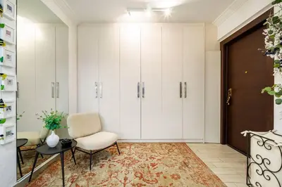 a room with white cabinets and a chair and a table at The excellent home in Athens