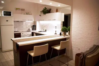 a kitchen with a counter and two stools at The excellent home in Athens