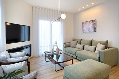 a living room with a couch and a tv at Eos Residence in Athens
