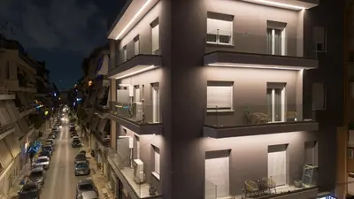 a tall white building with windows and a street at Eos Residence in Athens