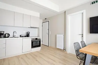 a kitchen with white cabinets and a table and chairs at Eos Residence in Athens