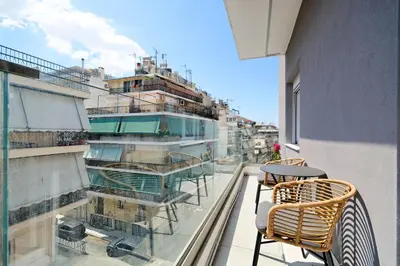 a balcony with a table and chairs on a building at Eos Residence in Athens