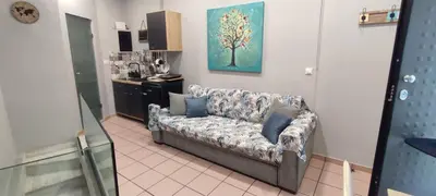 a living room with a couch and a kitchen at Alley's house Athens in Athens