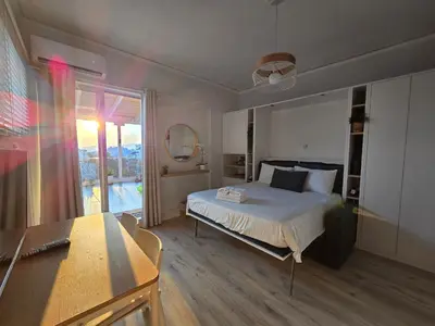 a bedroom with a bed and a large window at Penthouse Nea Smirni in Athens