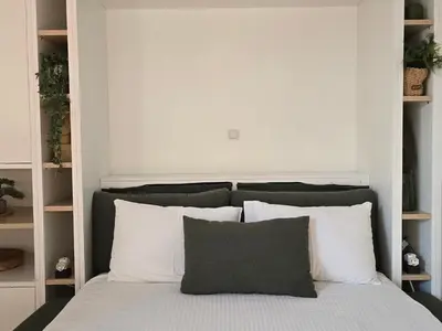 a bedroom with a bed with white pillows at Penthouse Nea Smirni in Athens