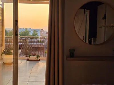 a room with a mirror and a view of a balcony at Penthouse Nea Smirni in Athens