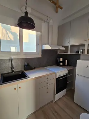 a kitchen with white cabinets and a sink at Penthouse Nea Smirni in Athens