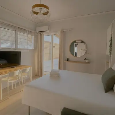 a white living room with a table and a mirror at Penthouse Nea Smirni in Athens
