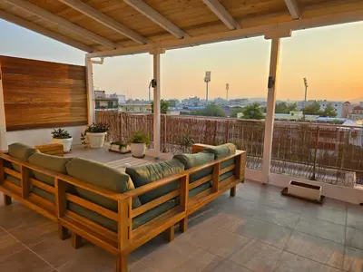 a couch on a balcony with a view of the city at Penthouse Nea Smirni in Athens