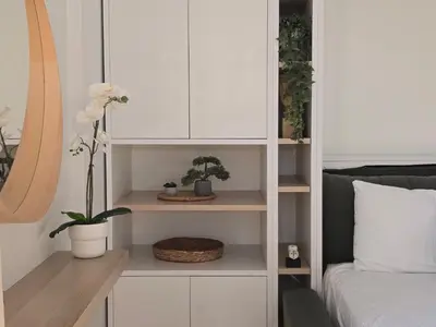 a bedroom with a white cabinet with potted plants at Penthouse Nea Smirni in Athens