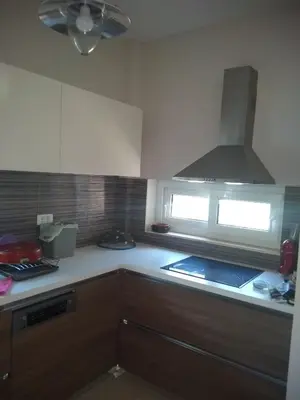 a kitchen with wooden cabinets and a stove top oven at Cozy villa Vita Lagonisi in Kalívia Thorikoú
