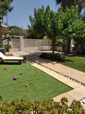 a backyard with a lawn with balls on it at Cozy villa Vita Lagonisi in Kalívia Thorikoú