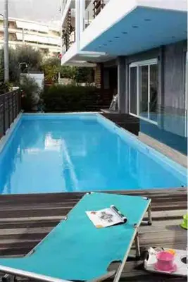 a large blue swimming pool with a table in it at The Love suite 1 Athens Riviera in Athens